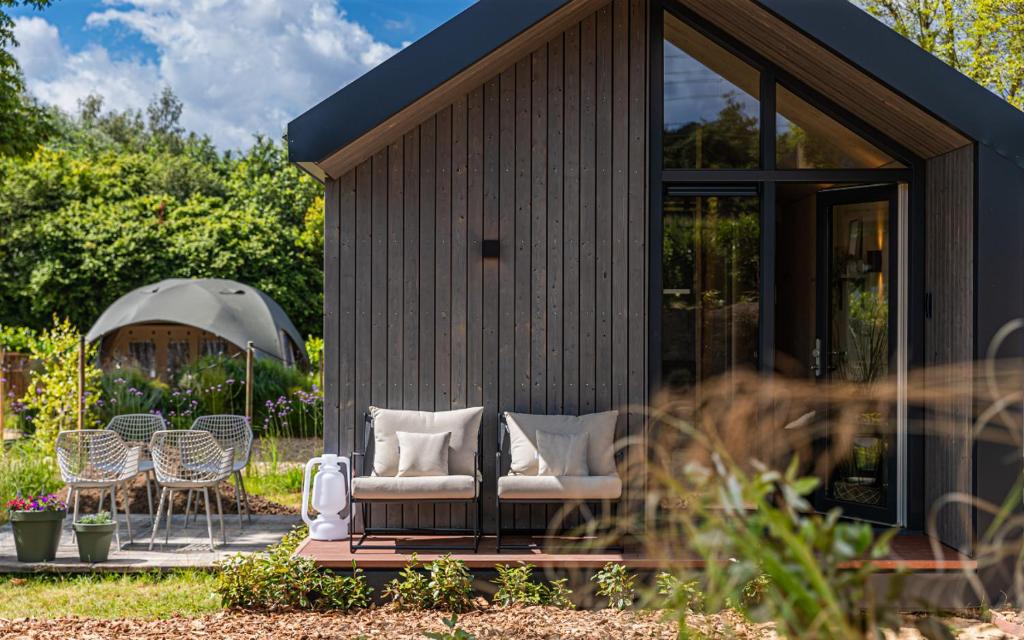 a small shed with chairs and tables and chairs at Tinyhouse luxe met privé hottub in Meerssen
