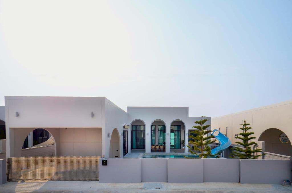 a large white building with a swimming pool at Hello Teepak A34 in Ban Bo Prakhon