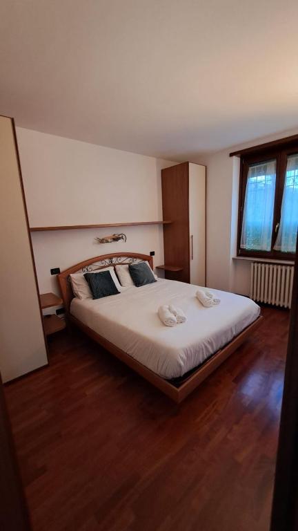 a bedroom with a large white bed with wooden floors at Rolly Home - Verona Apartment in Verona