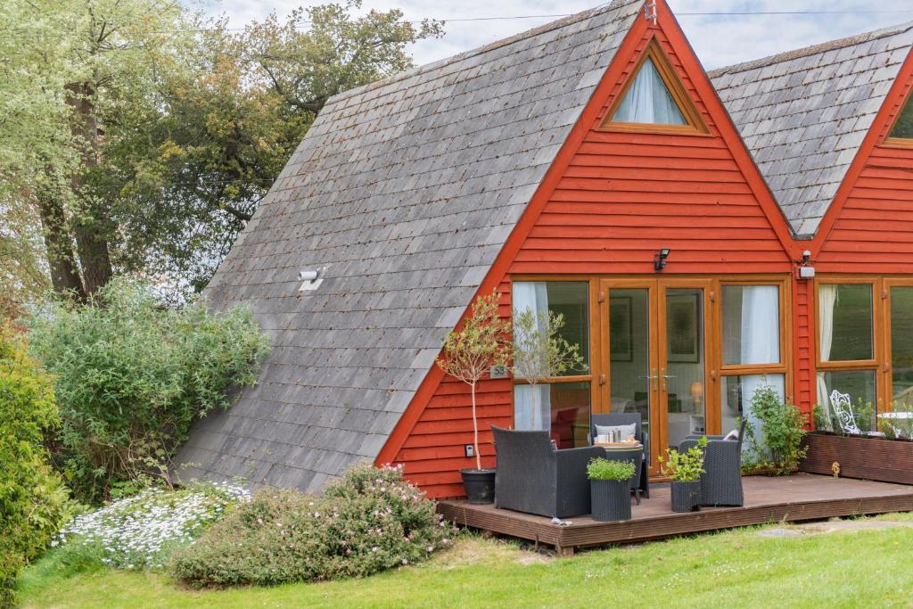 a house with a red roof with a porch at Chalet 53 in Deal