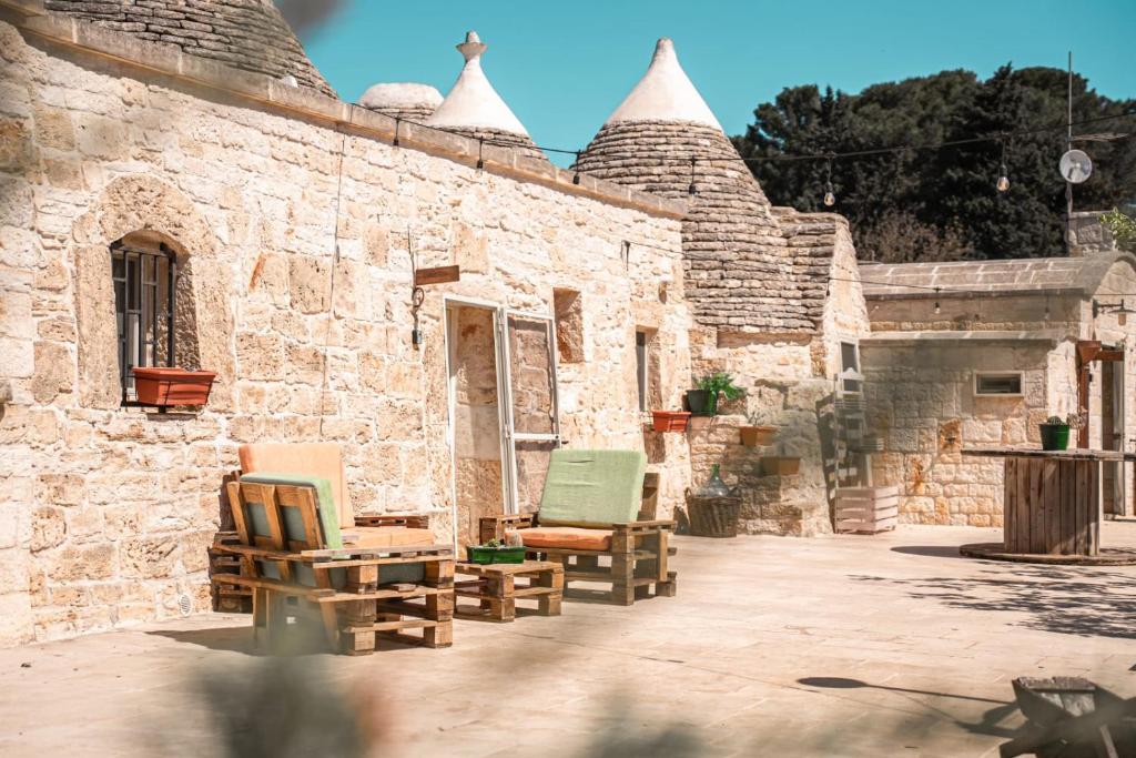 a group of chairs sitting on the side of a building at Trulli Beauty LAMIA family pool in Martina Franca