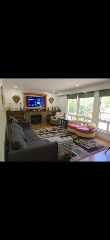 a living room with a couch and a flat screen tv at The Taunton House in Ajax