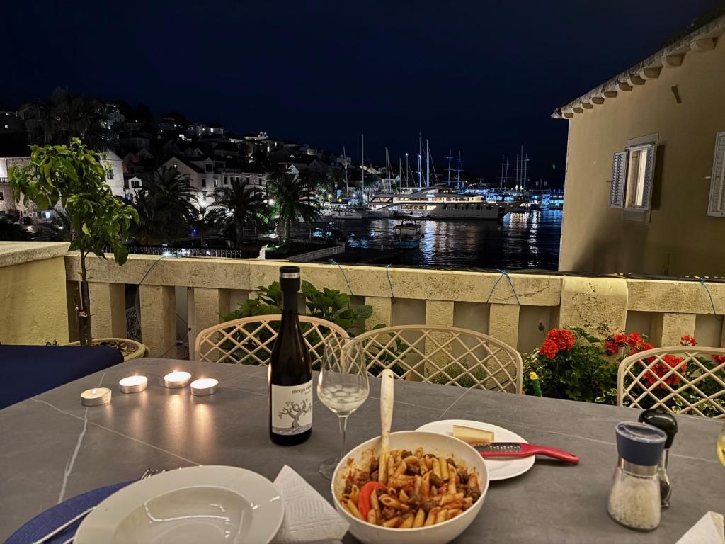 a table with a bowl of food and a bottle of wine at Riva Lavanda Hvar, Old Town in Hvar
