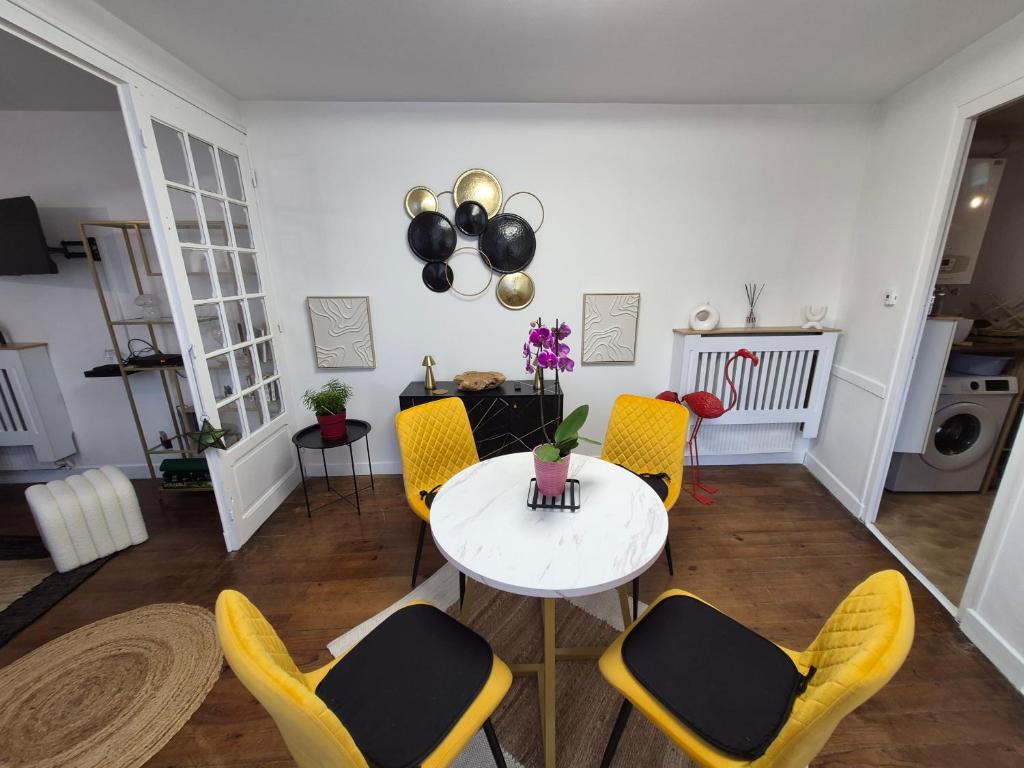 a living room with a table and yellow chairs at Candy house in Salies-de-Béarn