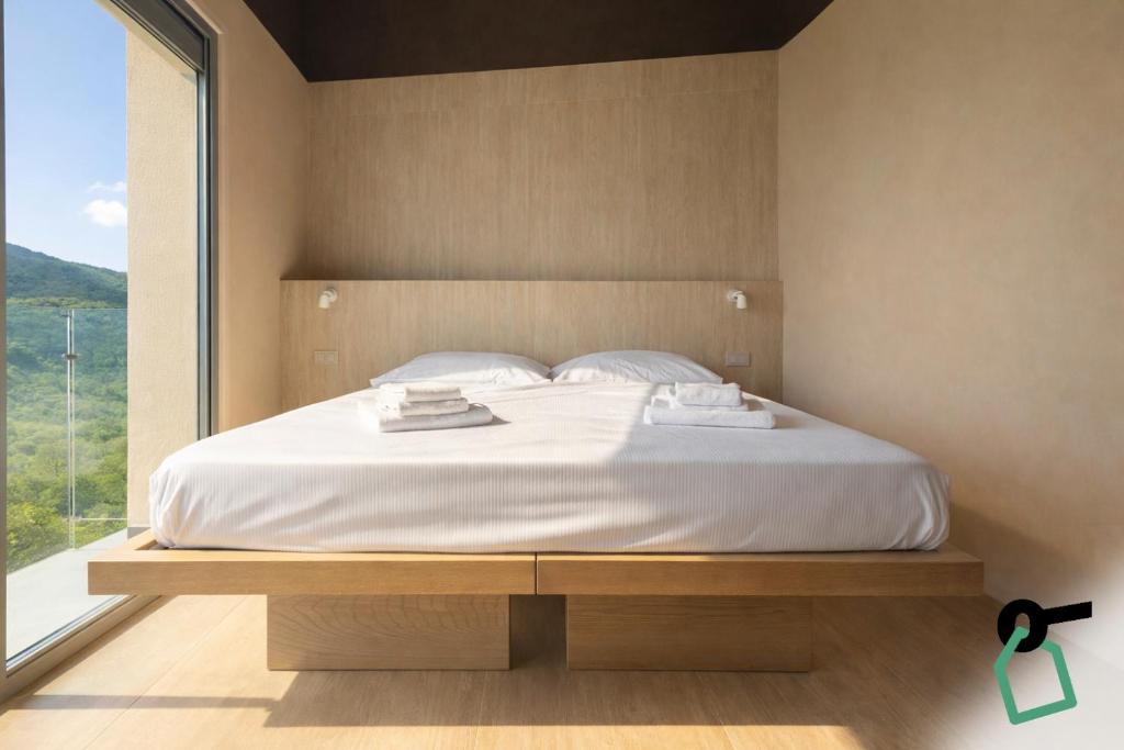 a bed in a bedroom with a large window at Hotiday Lerici Trebiano in Lerici