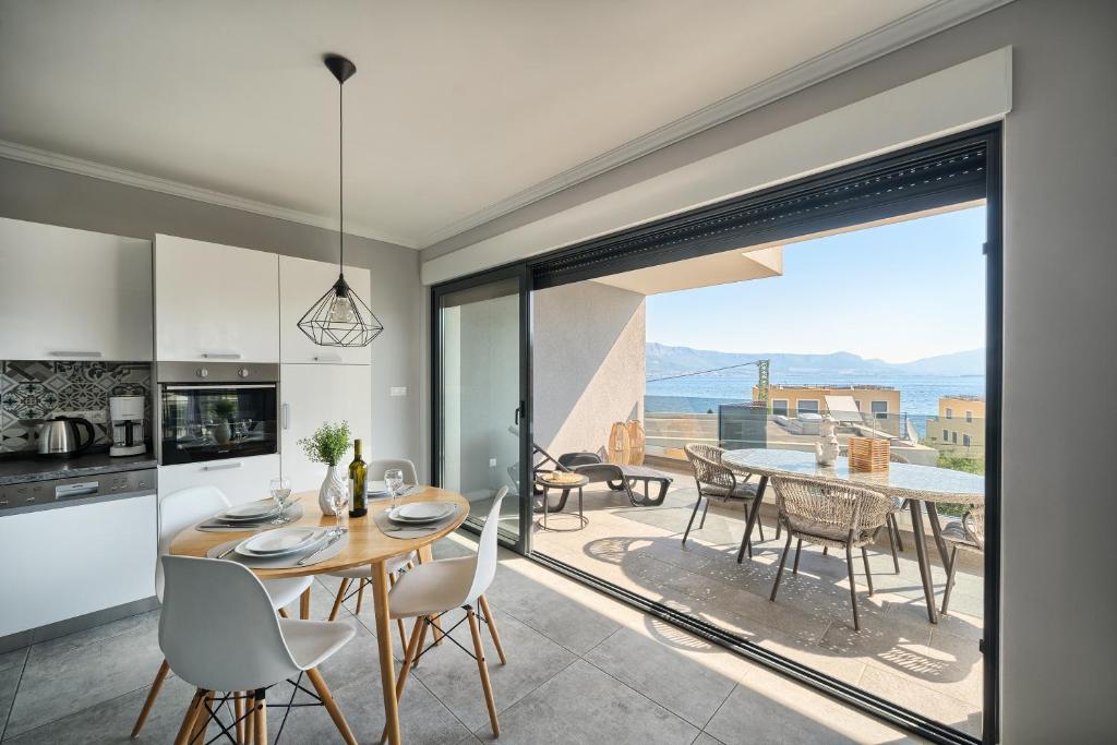 a kitchen and dining room with a table and chairs at Petra's Place - Sea view apartment in Slatine