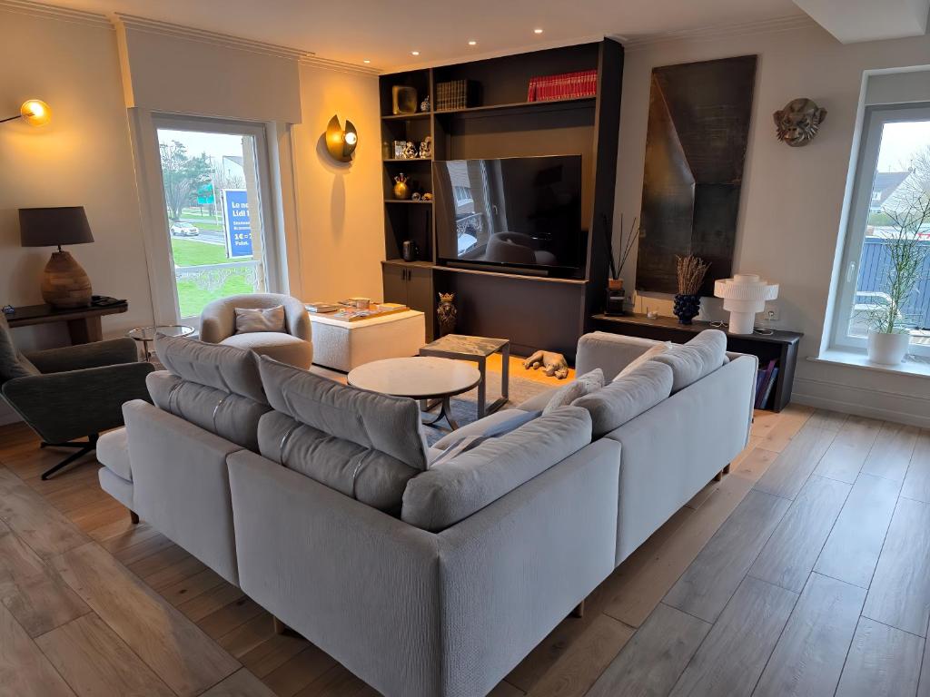 a living room with a large couch and a table at ATELIER DE BERCK - Gîte 6p avec Parking GRATUIT & TERRASSE in Berck-sur-Mer