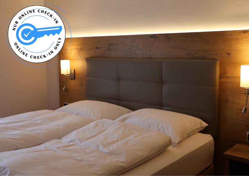 two beds in a bedroom with a sign on the wall at Hotel an der Therme in Bad Dürkheim