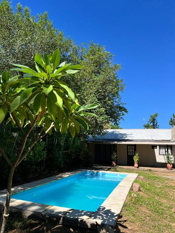 a blue swimming pool in front of a house at Casa Paso in Paso de la Patria