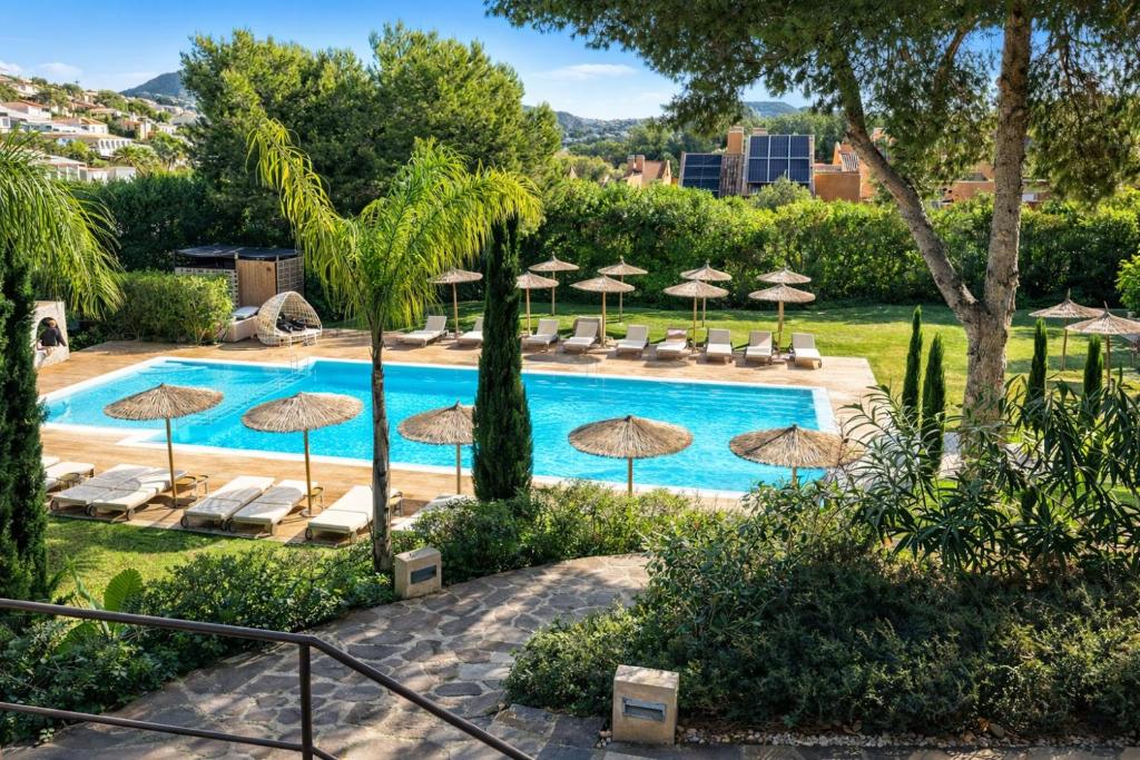 a swimming pool with umbrellas and chairs and a resort at Moraira Ritual de Terra By Elconserje in Moraira