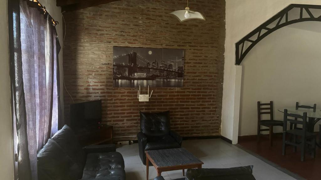 a living room with a couch and a brick wall at Casa La micelia in Pinamar