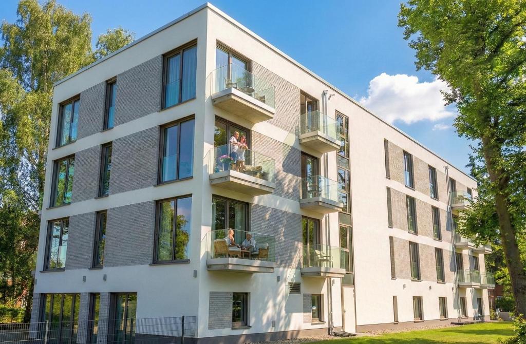 an apartment building with people sitting on the balconies at H24 Hotel Berlin Grünau in Berlin