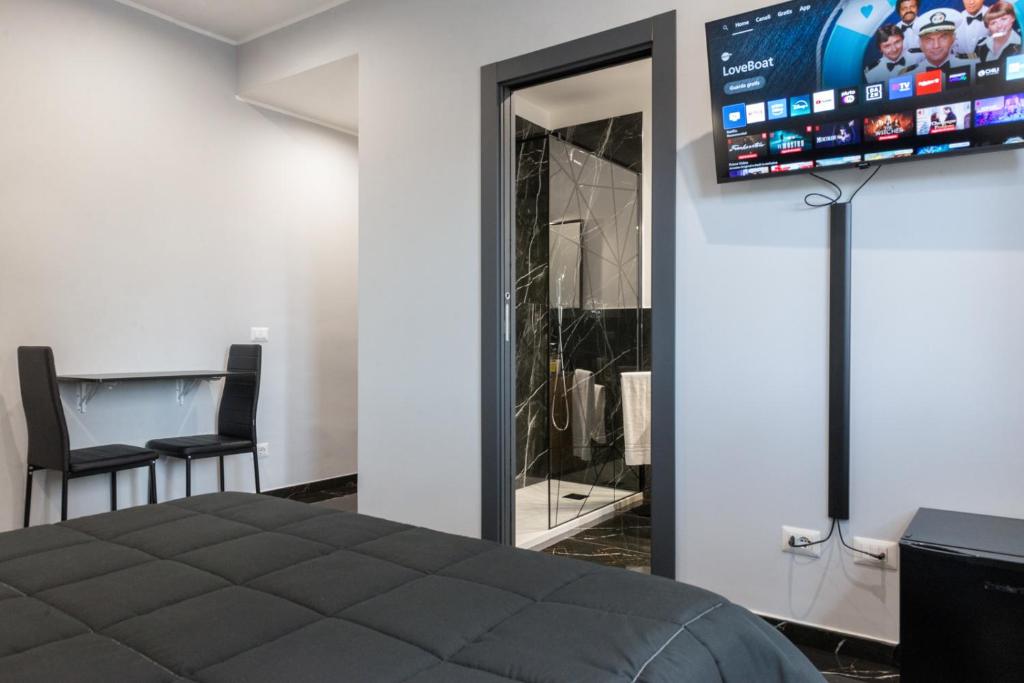 a bedroom with a tv on the wall and a bed at Magami Station Ciampino in Ciampino