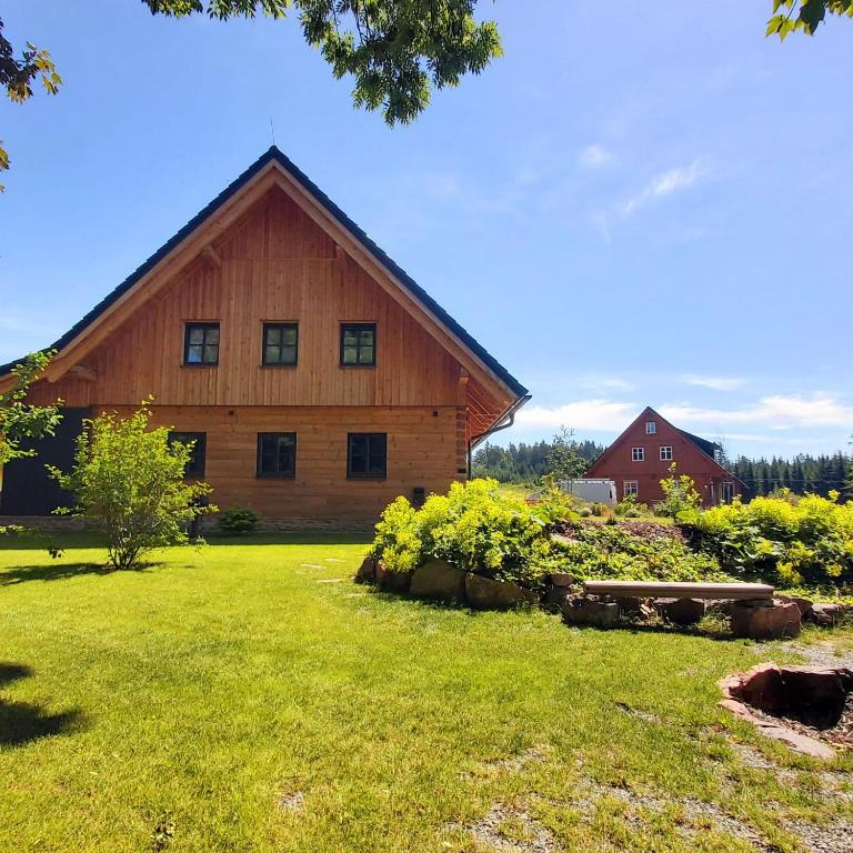 a large wooden barn in a field of grass at Roubenka Panské Pole in Panské Pole