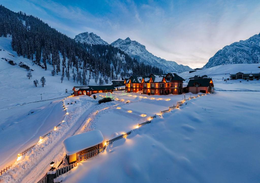 a group of lodges in the snow with lights at Hotel Village Walk in Sonāmarg