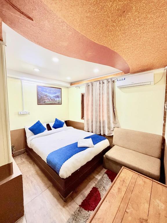 a bedroom with a large bed and a couch at Hotel Sakura & Tandoori Restaurant in Kathmandu