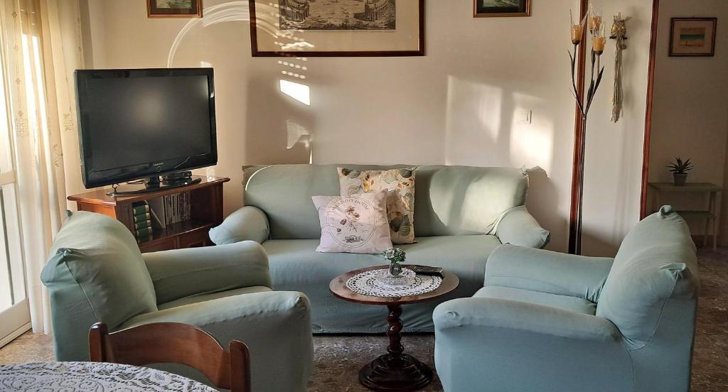 a living room with a couch and two chairs and a tv at Orlando House 1975 in Montecchio