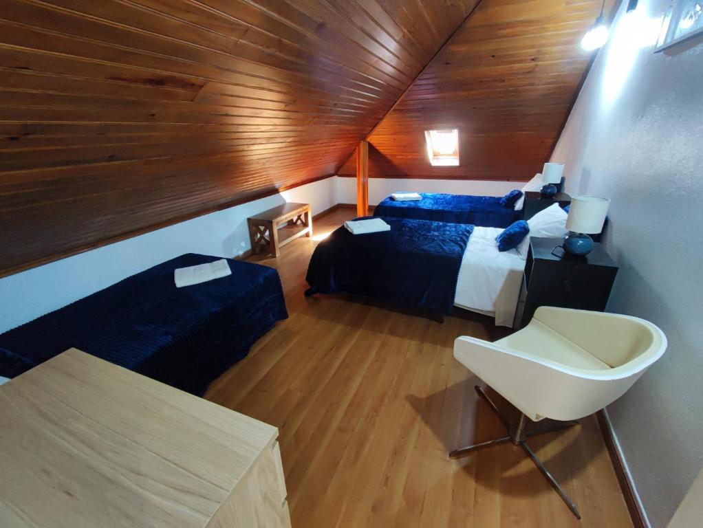 a attic bedroom with a bed and a desk at Alenquer, Alojamento Santa Catarina in Alenquer