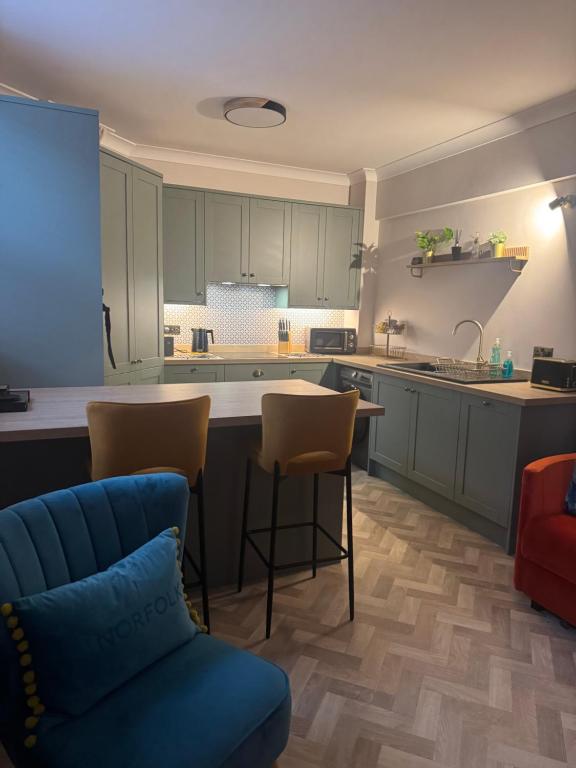a kitchen with green cabinets and a table and chairs at Half Moon Nest - Refurbished throughout for 2026 in Diss