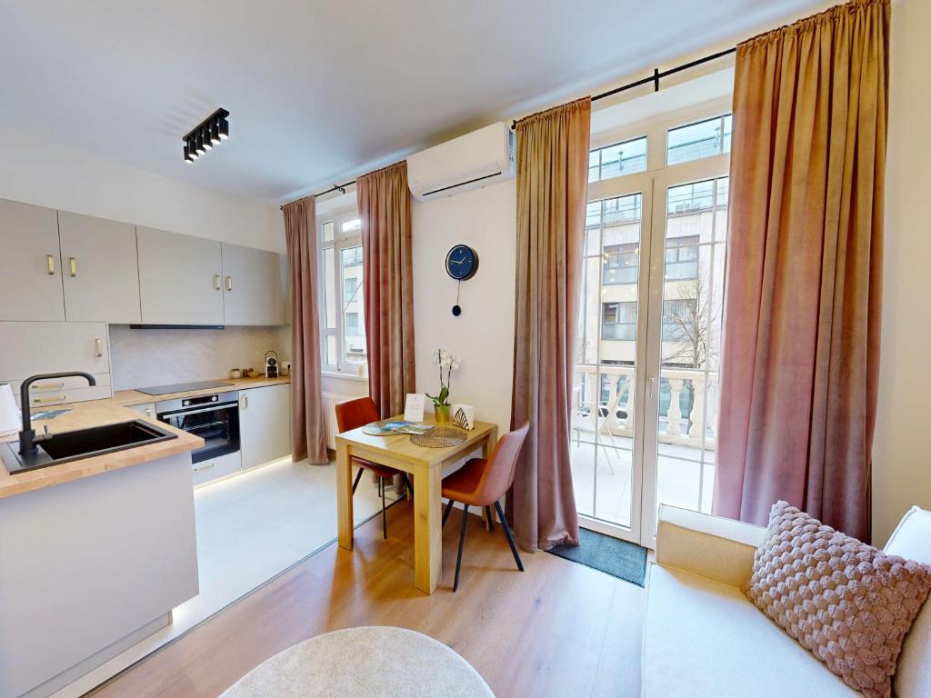 a kitchen and living room with a table and chairs at White Lotus Hévíz - 50 m from Thermal Lake in Hévíz