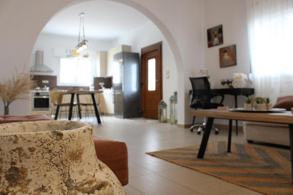 a living room with a couch and a table and a piano at SunΚissed Home - Pollonia Milos in Pollonia