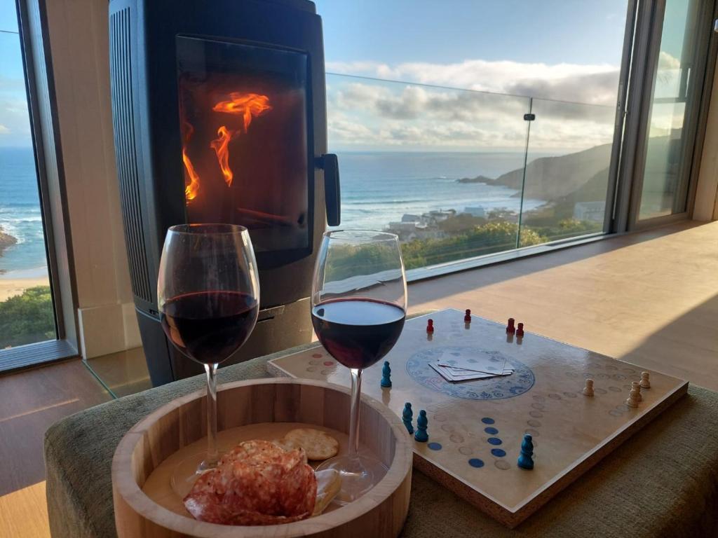 a glass of red wine next to a fireplace at Salt & Soul in Herolds Bay