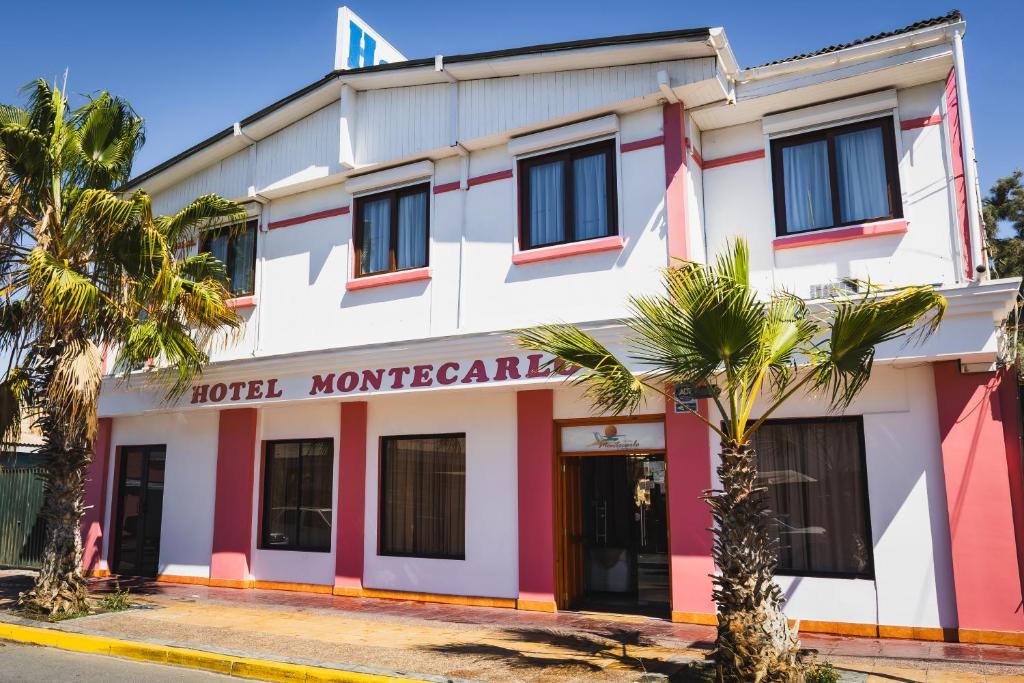 a hotel monterey building with palm trees in front at Hotel Montecarlo in Caldera