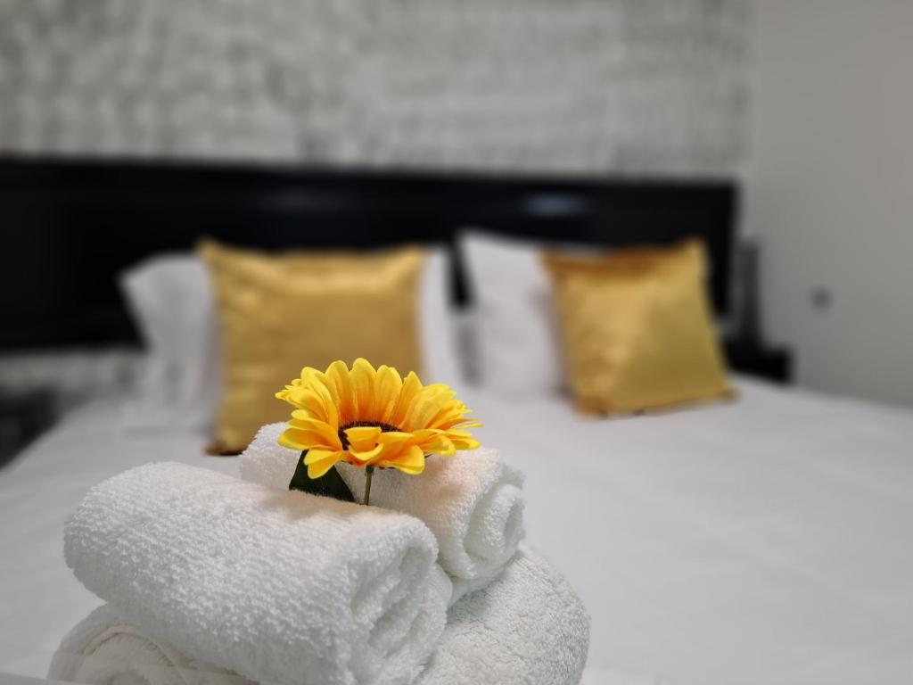 a towel pile with a yellow flower in it at The Bello Lodging B in Sonsonate