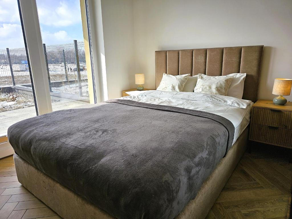 a bedroom with a large bed with a large window at Borki Lake View Apartment in Radom
