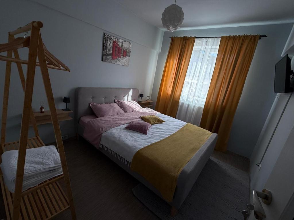 a bedroom with a bed with pink sheets and a window at Thaleia Retreat in Ocna-Mureşului