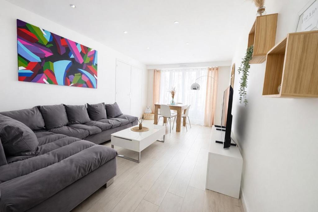 a living room with a couch and a table at Appartement Chilly Mazarin T3 Proche Aéroport Orly in Chilly-Mazarin