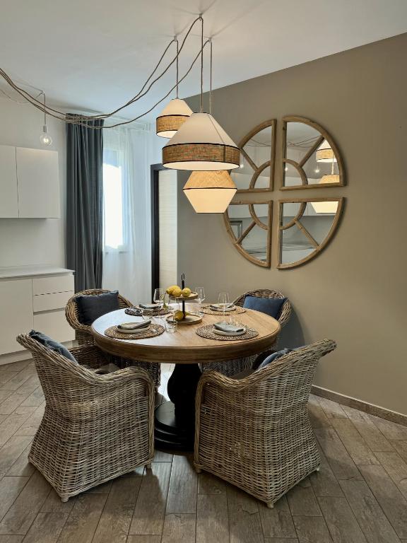 a dining room table with chairs and a mirror at Grecale - Villa Marina in Marina di Andora