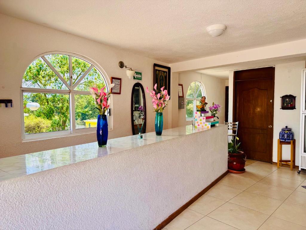 a kitchen with two vases with flowers on a counter at Hotel Hacienda Real, Villa in Villa del Carbón