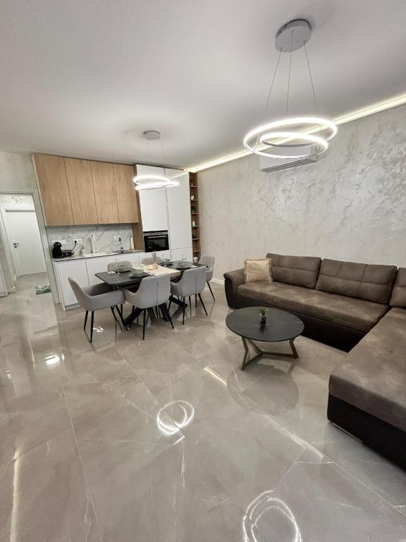 a living room with a couch and tables and a kitchen at Le bijou Lauta Forest in Plovdiv