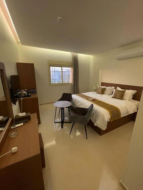 a bedroom with a bed and a table and a chair at شقير للغرف الفندقية 1 in Medina