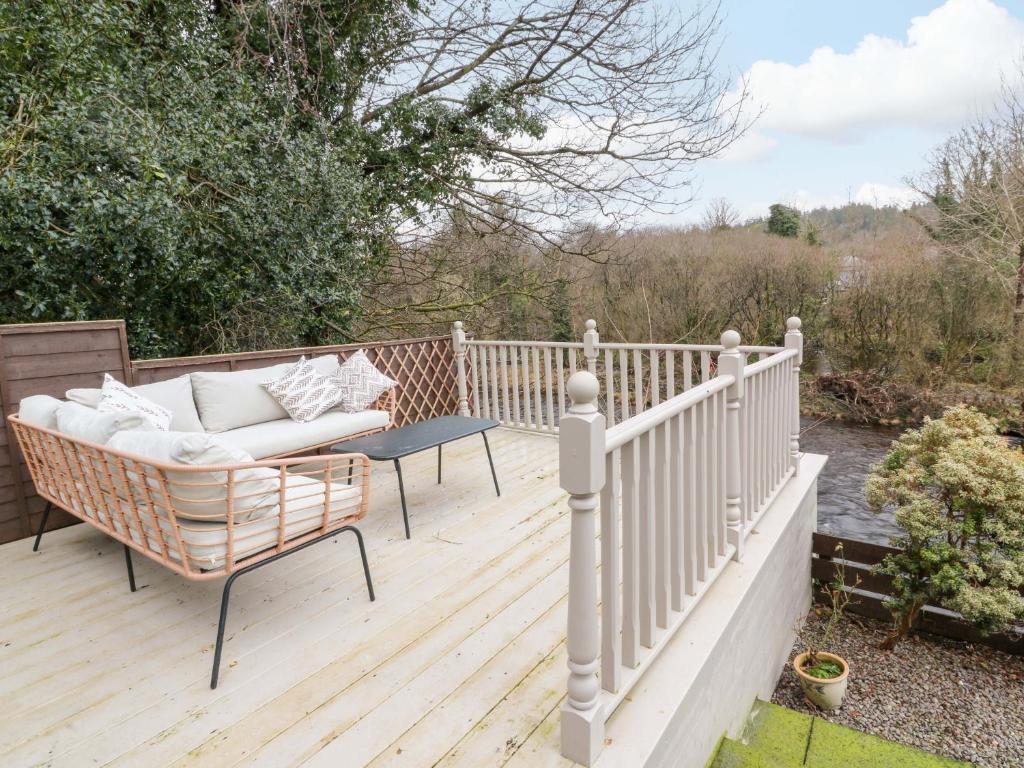 a porch with a couch and a table on a wooden deck at 7 Brewery Pool in Newton Stewart
