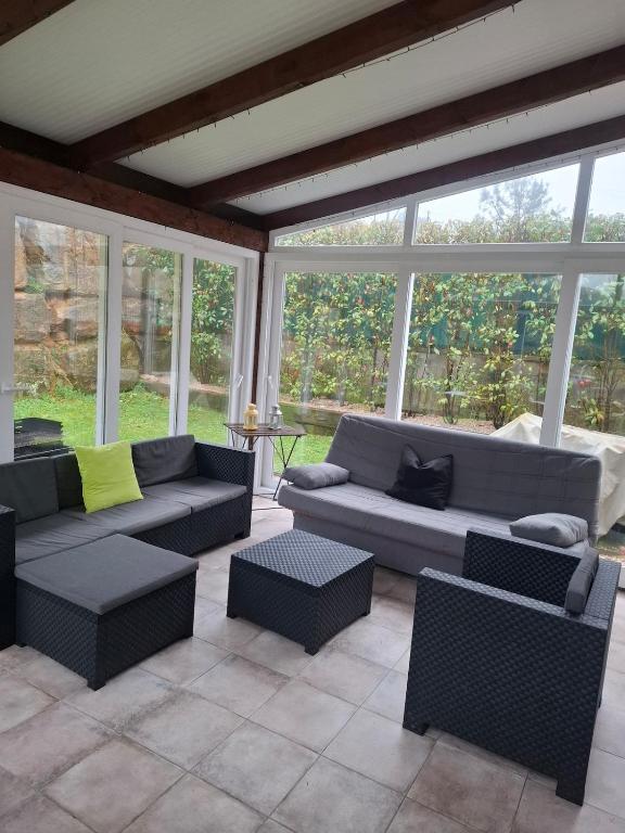 a living room with couches and chairs and windows at Casa familiar katandres in San Mamés de Meruelo