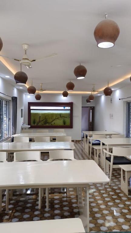 a dining room with tables and a flat screen tv at CHAYAA BITHII Resort & Restaurant in Kopāi