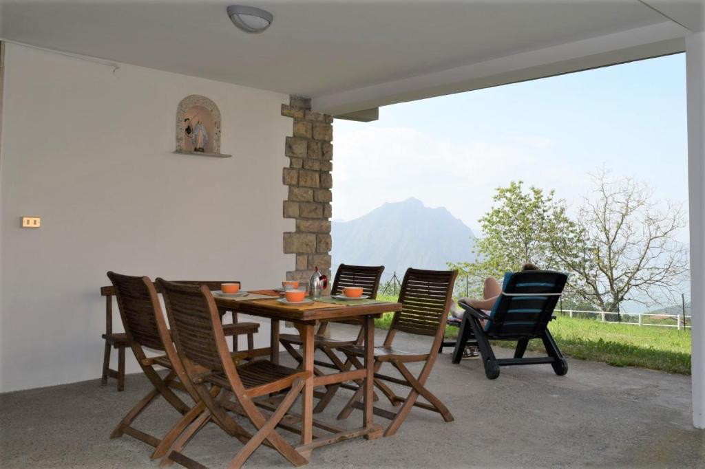 a wooden table and chairs on a patio at Il Roseto Mountain Lake Iseo Hospitality in Bossico