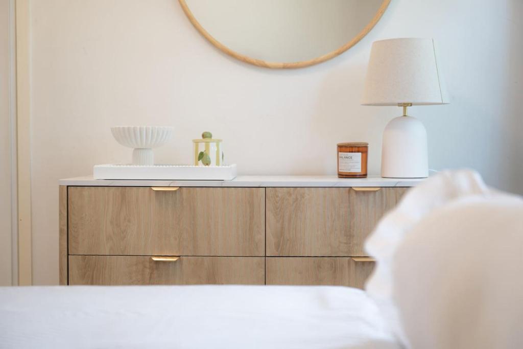 a bedroom with a dresser with a lamp and a mirror at Comfortable Home for 6 - Canberra Inner North in Belconnen