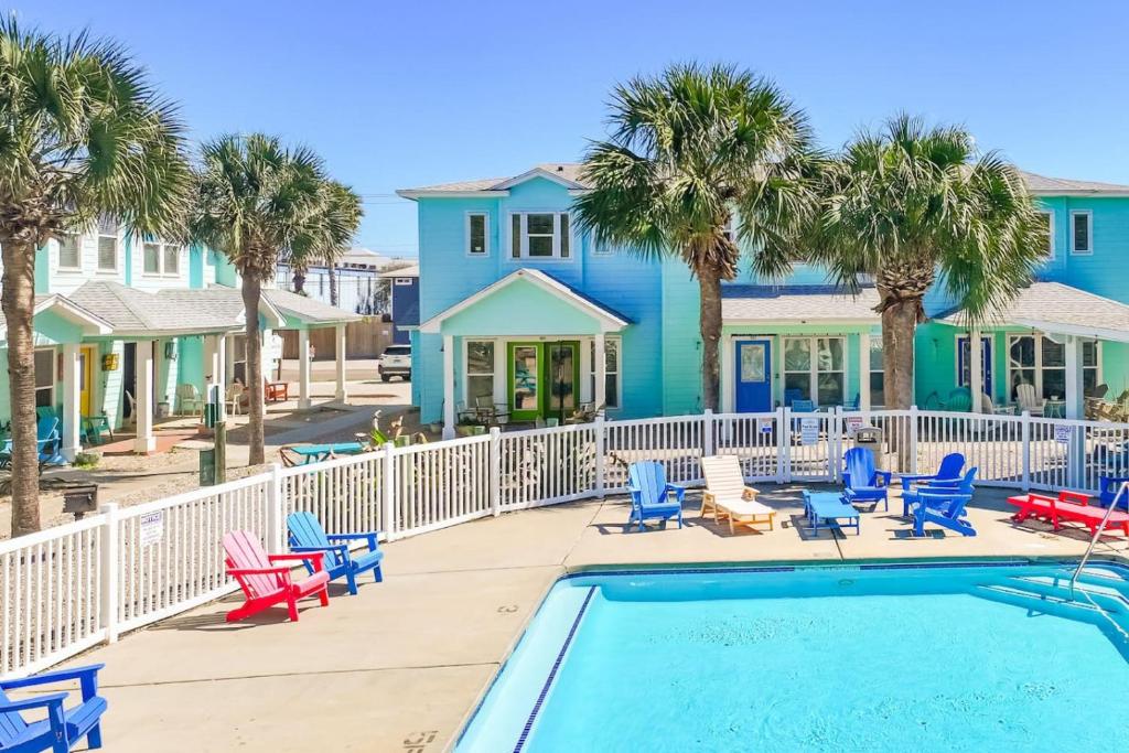 a villa with a swimming pool and palm trees at La Concha Cottage in Port Aransas