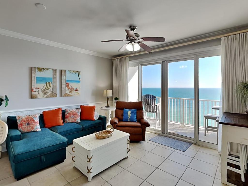 a living room with a couch and chairs and a balcony at Windemere #1104 in Perdido Key