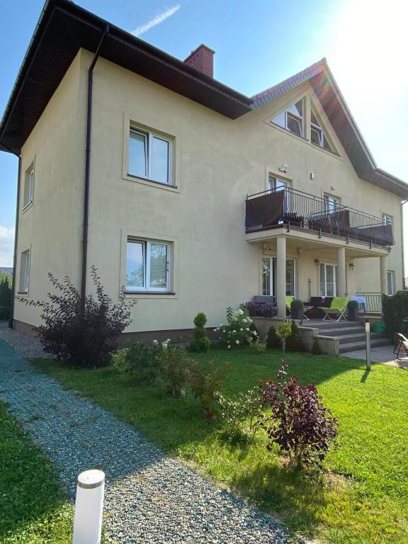 a large house with a balcony and a yard at Villa Spokojna 26 in Mielno