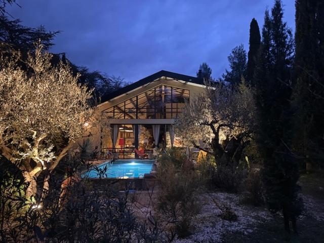 a large house with a swimming pool in front of it at VILLA Nîmes tourmagne PISCINE in Nîmes