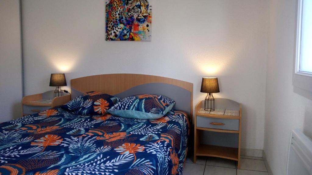 a bedroom with a bed and two night stands with lamps at Les Clés Nature Apt 44 in Moutiers-sous-Chantemerle
