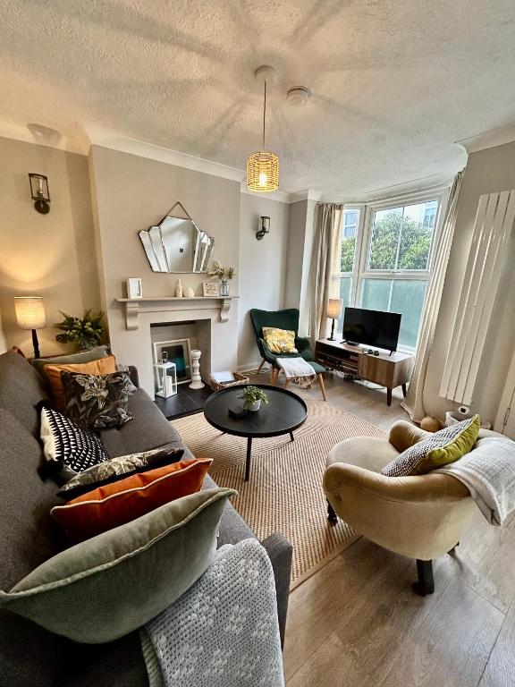a living room with a couch and a table at Sea Song Cottage in Broadstairs