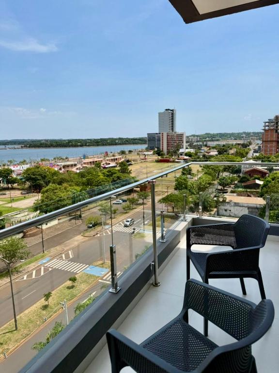 un balcone con due sedie e vista sulla città di Milord Suites a Encarnación