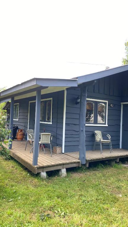 a blue house with two chairs and a porch at Cabañas Arte Patagonia in Puyehue