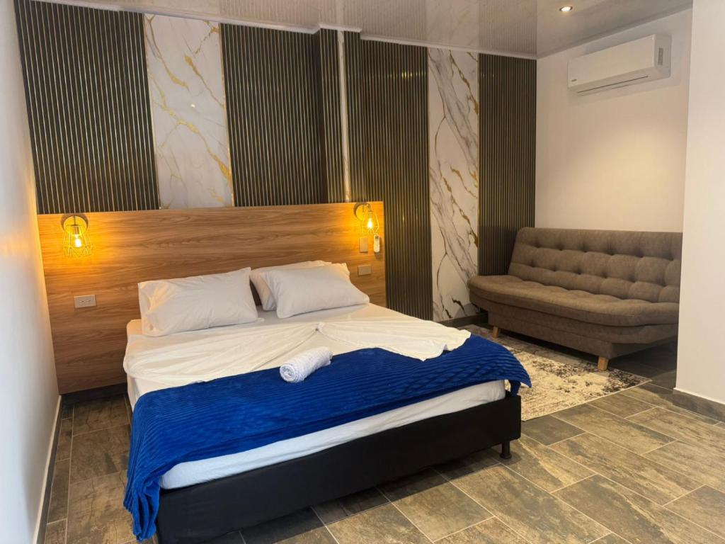 a bedroom with a large bed and a couch at aparta hotel del toro in Estación El Salto