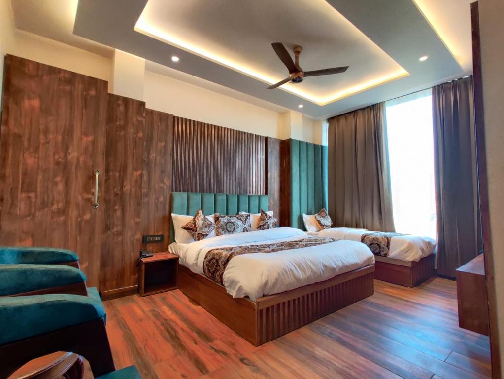 a bedroom with two beds and a ceiling fan at Hotel Absolut Comfort 500 MTR FROM GOLDEN TEMPLE in Amritsar